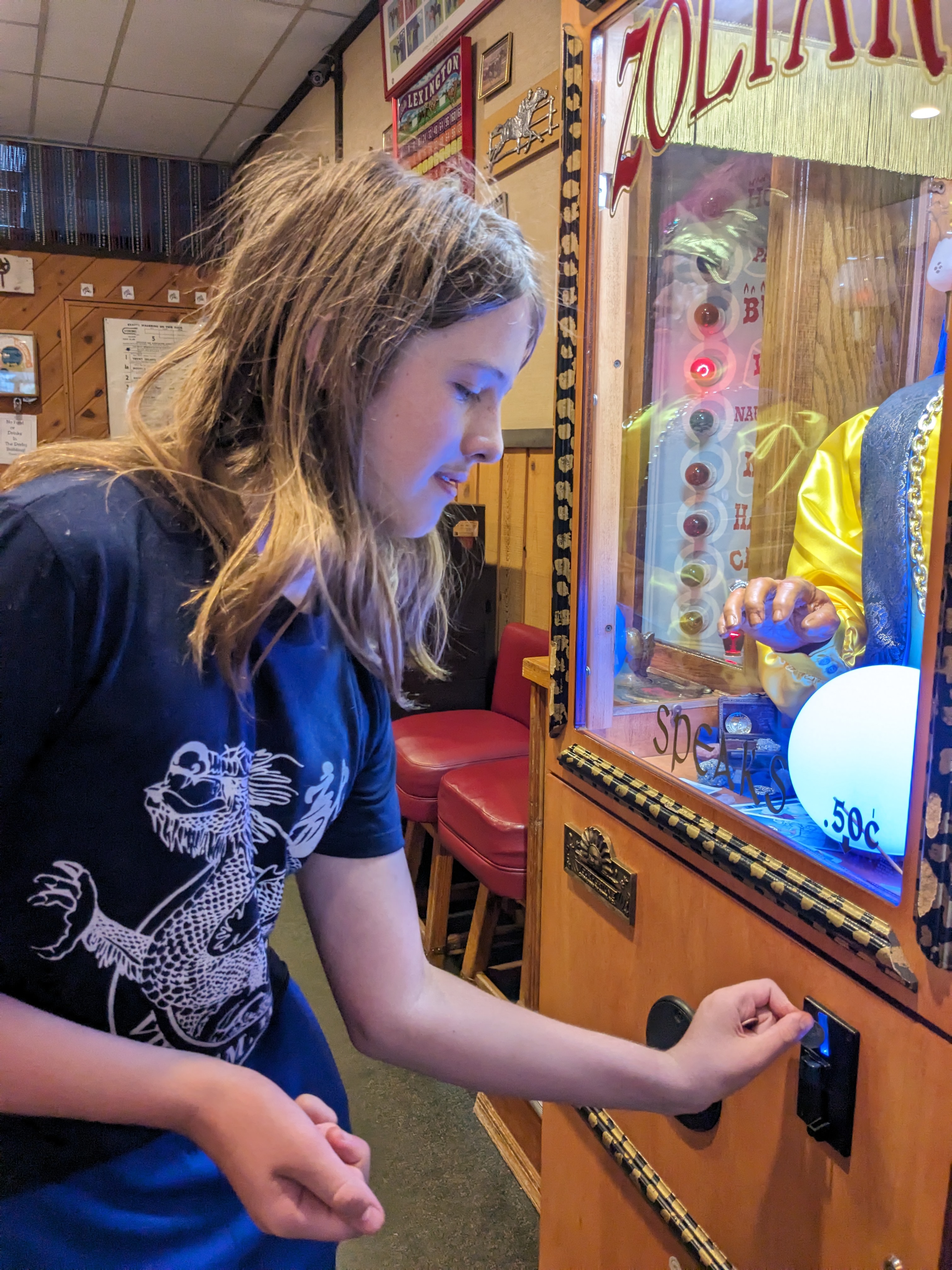 Silas putting money in the Zoltar machine